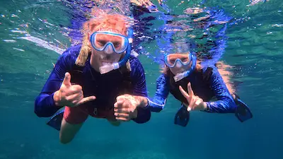 Two guests snorkeling underwater during a small-group Ishigaki snorkeling tour with English-speaking guide